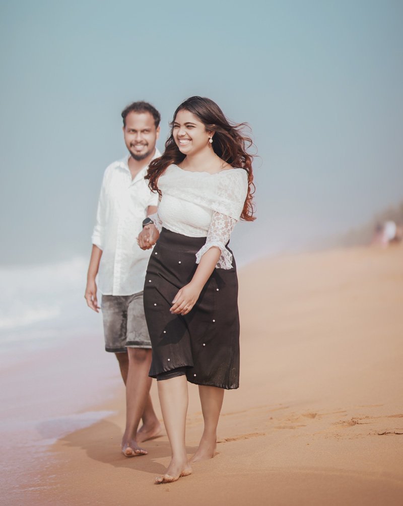 Couple walking barefoot along a beach