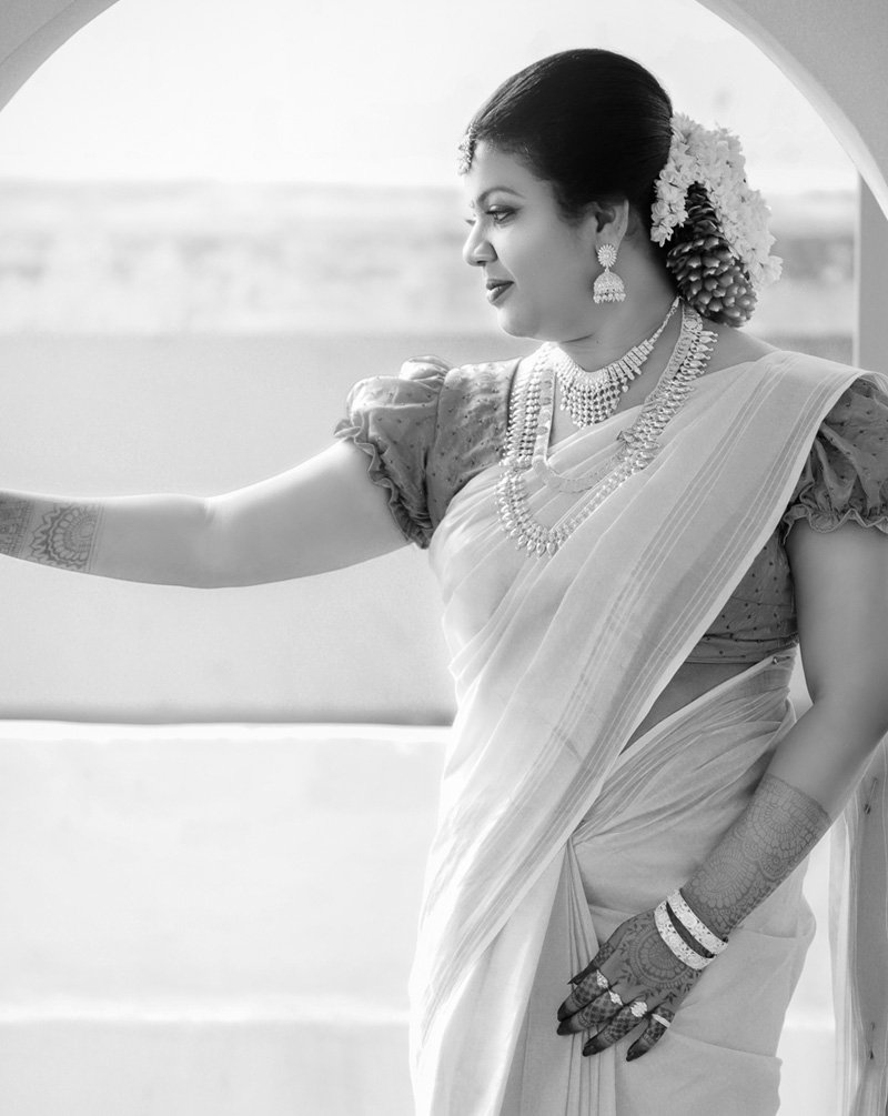 Black and white portrait of a woman in a saree with jasmine flowers in her hair